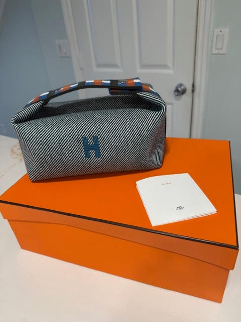 Hermès Le Liège case: Limited Edition Canvas & Leather Travel CaseA rare and sophisticated Hermès Le Liège case featuring the iconic H embroidery in deep blue tones with signature Hermès striped detailing on the handle.