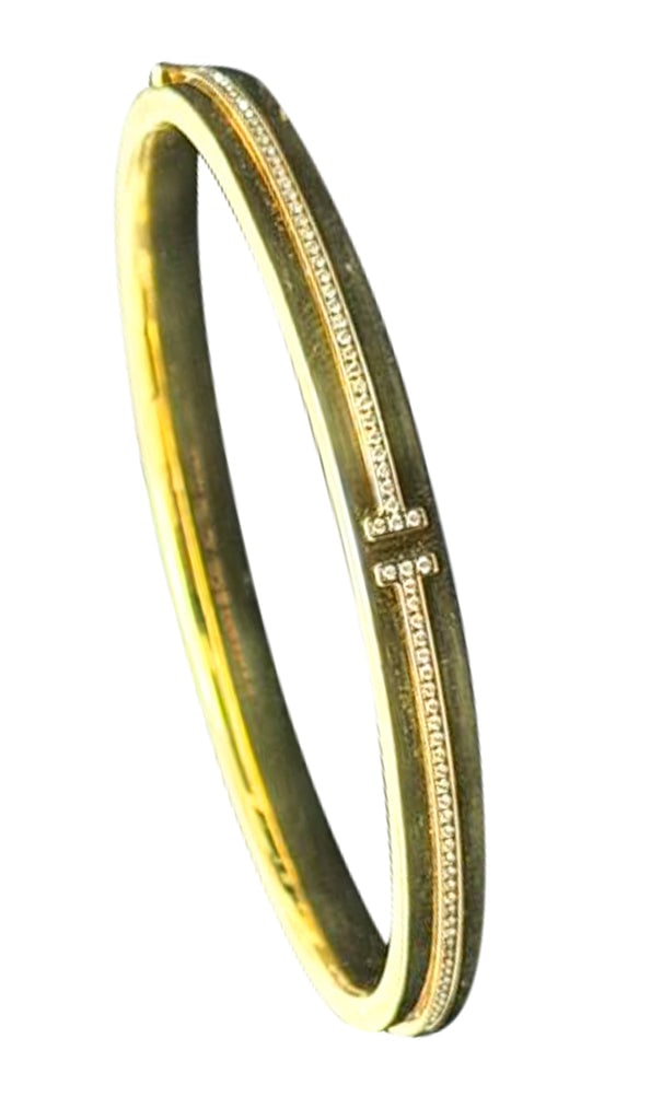 TIFFANY & CO. Hinged T-Bracelet In 18Kt Yellow Gold With VVS Diamonds: T-Bracelet with diamonds designed by Tiffany & Co.This is a beautiful diamond hinged bracelet from the celebrated Tiffany T-collection by Tiffany & Co. The bracelet has been carefully crafted in solid