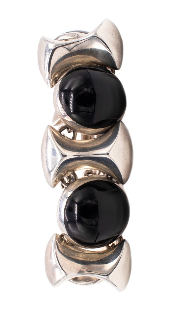 MEXICO 1970S VINTAGE RETRO BRACELET IN .925 STERLING WITH ONYX CABOCHONS: RETRO MODERNIST BRACELET MADE IN MEXICO.NICE GEOMETRIC BULK BRACELET, MADE IN TAXCO, MEXICO AROUND THE 1970'S. IS CRAFTED IN SOLID .925/1000 STERLING SILVER AND SUITED WITH A PUSH LOCK.BEZEL MOUNTED W