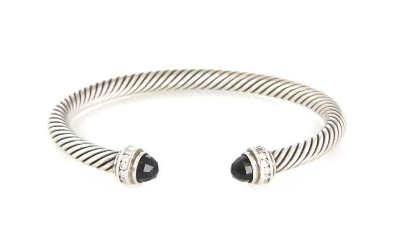 David Yurman Diamond Onyx Sterling 5mm Cable Cuff Bracelet LIQUIDATION: This is an authentic cuff bracelet by David Yurman, it is crafted from sterling silver featuring a 5mm thick cable wire band with a faceted cut black onyx gemstone on each end accented with sparkling 