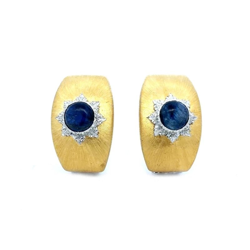 Buccellati Rigato Gold Earrings Sapphire Starburst 18k Two Tone Clip On Style: The Buccellati Gold Earrings are a luxurious and stunning piece of fine jewelry. These earrings feature a curved wide band with a silky, fabric-like engraving technique which produces a silky fabric l