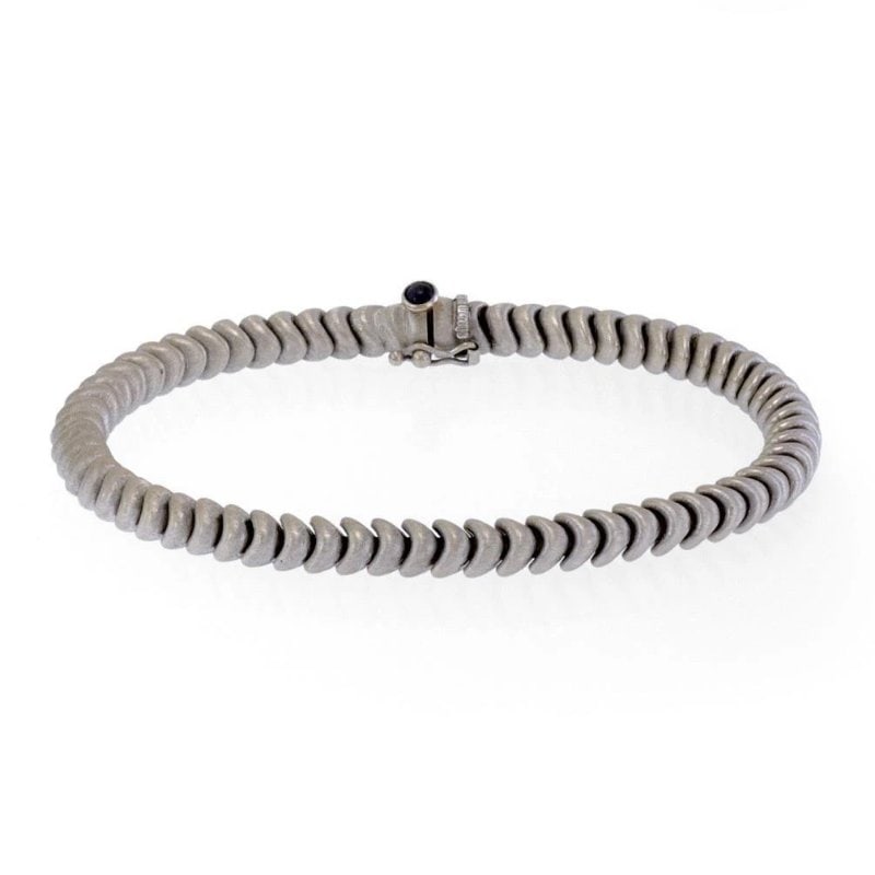 Chiampesan Sapphire 18k White Gold 5mm Fancy Link Bracelet: This elegant designer signed 5mm thick bracelet is from Chiampesan, crafted from 18k white gold with a shiny satin finish featuring chasing spiga shape links. It secure with a slide clasp accented wit