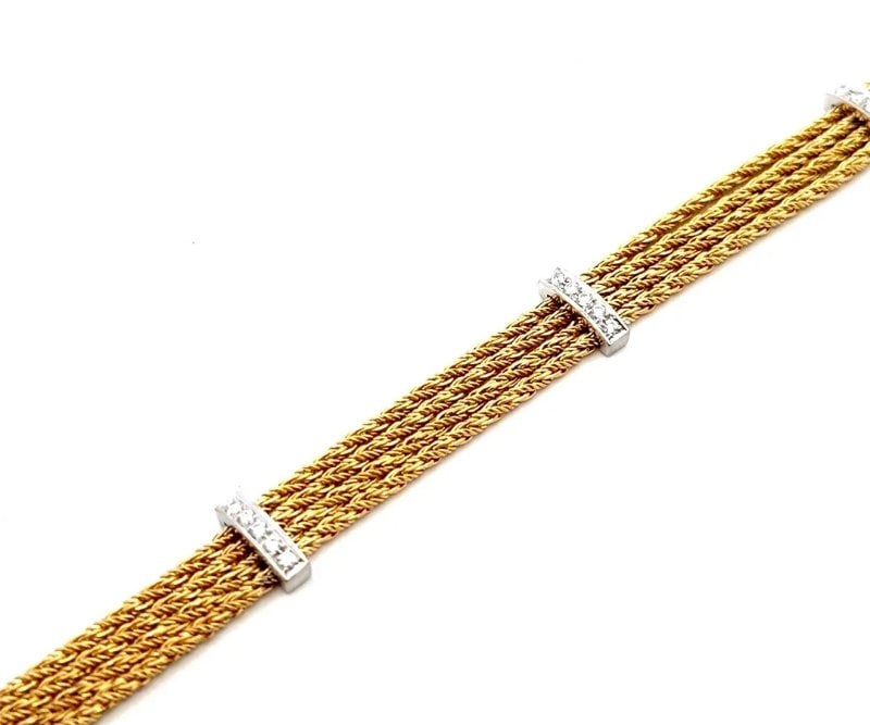 Tiffany & Co. Draperie Gold Bracelet Diamond Bar 18k Two Tone Multi-strand: This lovely vintage bracelet is by Tiffany & Co. from the Draperie Collection. The 18k yellow and white gold multi-strand bracelet is composed of four parallel glittering woven rope chains with white 
