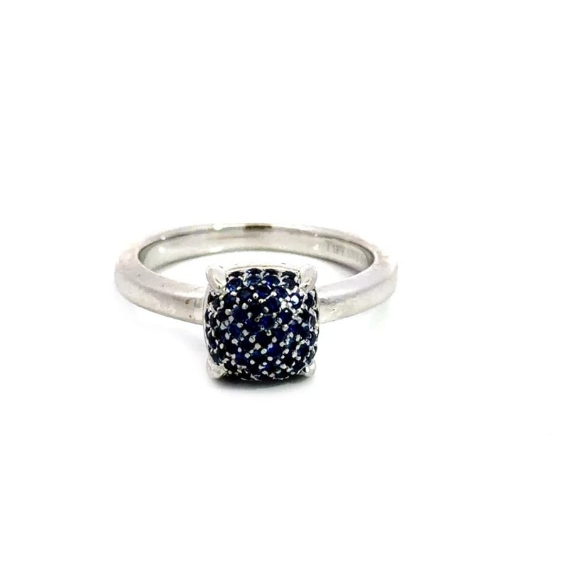 Tiffany & Co. Picasso Gold Ring Sapphire Sugar Stack 18k White Paper Pouch: The product is an elegant Tiffany & Co. Picasso Gold Ring featuring a dome cushion shape top with blue sapphires. The ring is set in 18k white gold with pavé setting style, making it a luxurious and 