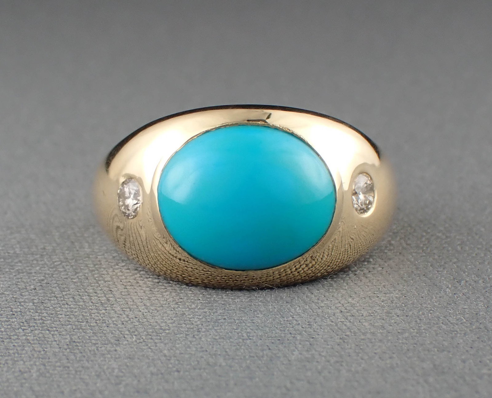 TURQUOISE, DIAMOND & 14K YELLOW GOLD RING: TURQUOISE, DIAMOND & 14K YELLOW GOLD RING:set with a pair of round-cut diamonds weighing 0.18 cttw, and centered with a 3.45 cts. oval turquoise cabochon. The ring weighs 3.4 grams and is stamped "14K