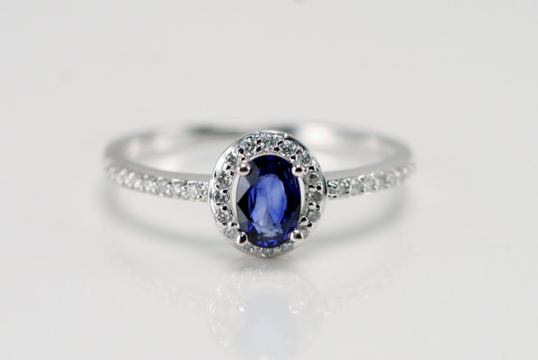 14K W/G OVAL CUT SAPPHIRE RING WITH DIAMONDS: 14K W/G RING WITH .20 CTS DIAMONDS AND .52 OVAL CUT SAPPHIRE. VALUE $1100 R:225