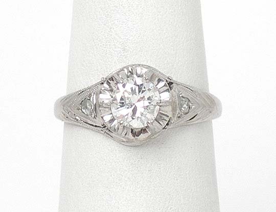 PLATINUM & 60 PT ROUND DIAMOND SOLITAIRE RING: This is a gorgeous vintage diamond solitaire ring crafted in platinum with rose cut diamond accents. The ring features a 60 point diamond set into a six prong setting in the center. The platinum has a