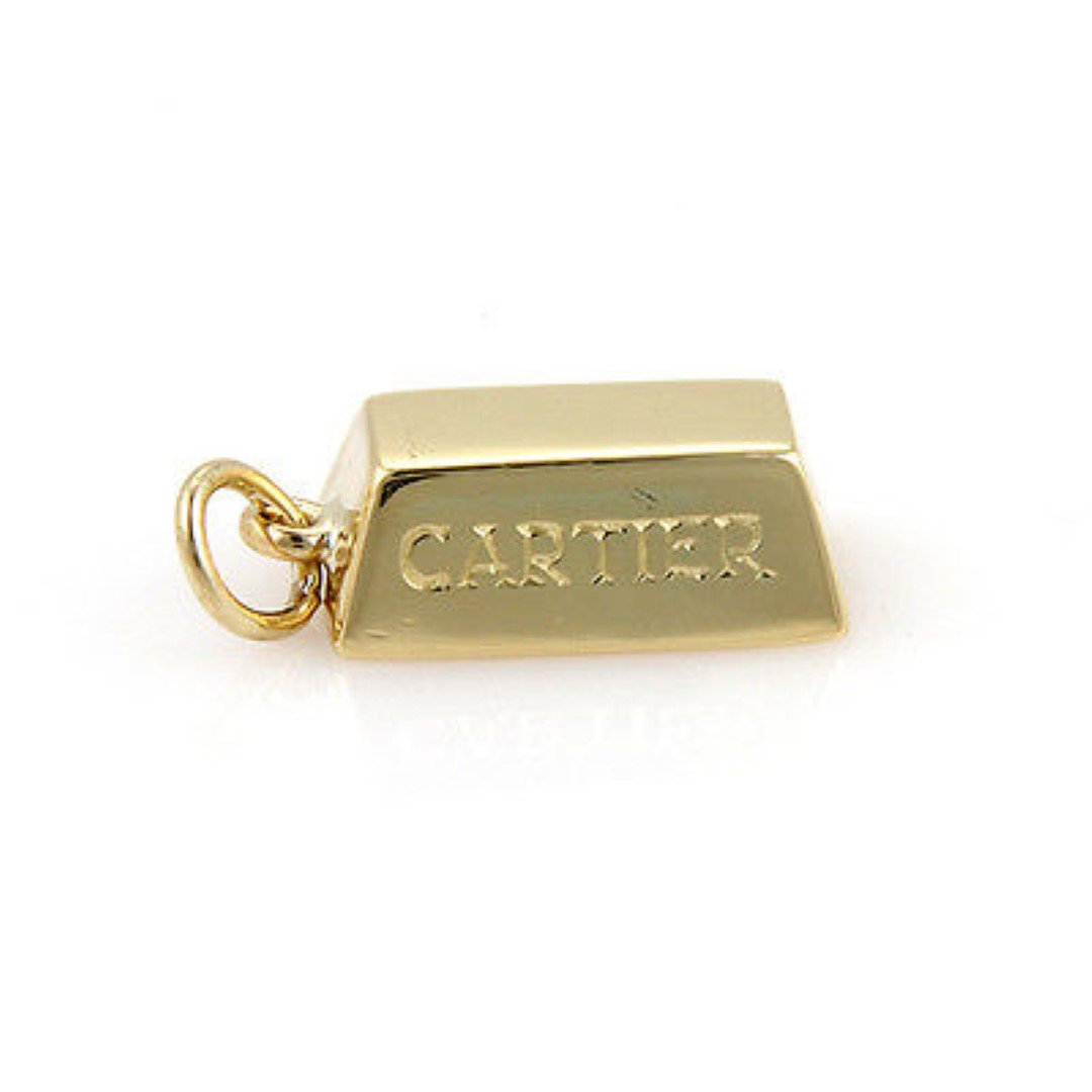 Cartier 18K Yellow Gold 1/2 oz. Gold Bar Ingot Pendant: This authentic Cartier piece is crafted from solid 18k yellow gold. This would be the perfect addition to your charm/pendant collection. It is fully signed with Cartier, 1/2 oz., and the gold content.