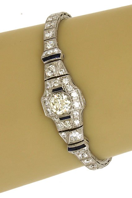 PLATINUM, 6.3 CTS DIAMONDS & 60 PTS. SAPPHIRES LADIES: This is an antique Art Deco platinum, diamonds and blue sapphires ladies ornate dress bracelet. The piece is exquisitely crafted in solid platinum with a smooth polished finish adorned with a massive 