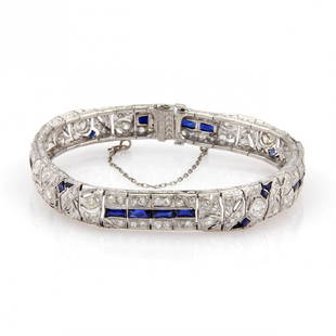 Art Deco Platinum 4.40ctw Diamond & Sapphires Bracelet: This gorgeous Arte Deco piece is finely crafted from platinum. It features 4.40ctw of sparkling diamonds along with 5ctw of man made blue sapphire gemstones set into an intricate Deco design. It faste