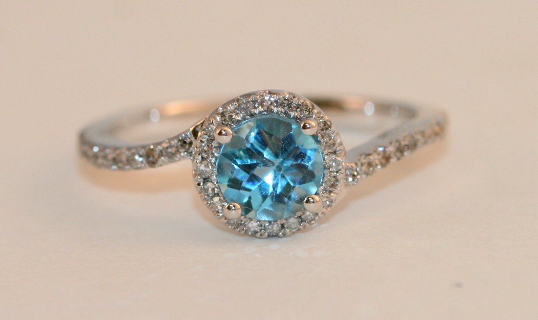 LADIES 14K W/G DIAMOND AND BLUE TOPAZ RING: LADIES 14K W/G DIAMOND AND BLUE TOPAZ RING. THIS STUNNING RING HAS A TOTAL DIAMOND WEIGHT OF .25CTS , ALL OF WHICH ARE FULL CUT ROUND BRILLIANT STONES. THE ROUND CUT BLUE TOPAZ WEIGHTS .80CTS - VALUE 