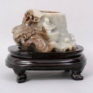 1081: VERY FINE CHINESE QING CARVED HETIAN JADE BRUSH P: QING HETIAN JADE WITH AREAS OF RUSSET, FINELY CARVED BRUSH POT TO DEPICTING A FIGURE SEAT ON CLIFF, WITH OPEN WORK OF TREES AND WAVES. ON WOODEN STAND