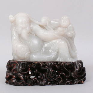 1125: CHINESE CARVED WHITE JADE BOULDER: FINE WHITE JADE CARVED TO DEPICT TWO DRUNK MEN LYING AGAINST WINEPOT AND OFFERING MORE DRINKS. COMES WITH CARVED WOODEN STAND