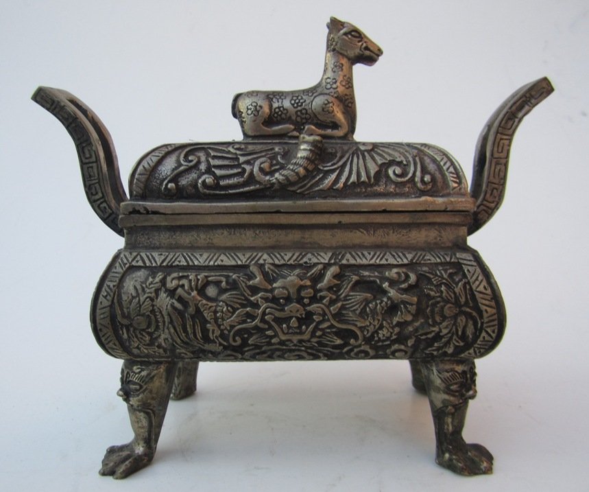 Chinese silvered bronze incense burner: Measurements: 4 3/4''H, 6 1/2''w at handles. 3''Deep. Chinese silvered bronze (white brass) incense burner, rectangular footed form, lid with lamb finial, body with foo dog heads and scroll work, paw 