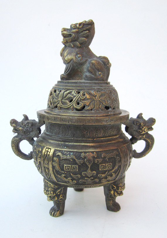 Chinese Bronze Incense Burner: Measurements: 8''H, 6''W at handles. Chinese bronze lidded incense burner raised on three feet, two side dragon handles, foo lion finial top. Marked: round seal mark on bottom. All base, stand or fram