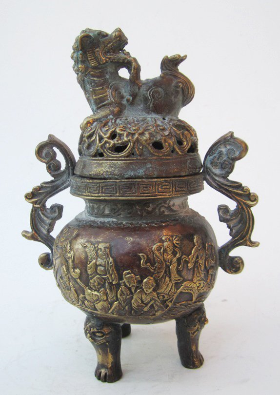 Chinese Brass & Bronze Incense Burner: Measurements: 7''H, 5''w at handles, 2'' x 2 '' x 2'' base. Chinese brass and bronze lidded container, raised on three feet, gilt raised figure decorated body, two scroll handles, pierced lid with foo