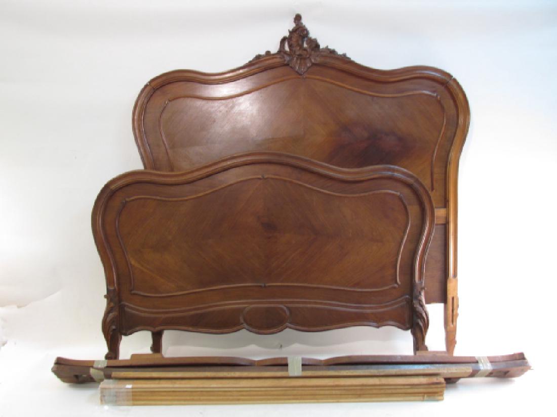 ROCOCO STYLE CARVED WOOD FULL SIZE BED FRAME: Rococo style carved wood full size bed frame. Headboard measures 61" tall x 58.5" wide. Footboard measures 37.75" tall x 58.5" wide. Includes rails and slats. Condition: a small repair to veneer on he