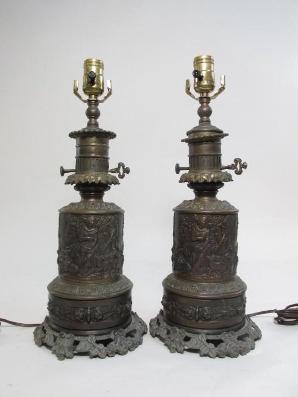 PAIR FRENCH EMBOSSED BRASS ELECTRIFIED OIL LAMPS: Pair of French embossed brass electrified oil lamps. Does not include shades or harps. Modern fixtures and wiring. Signed very small "Bourdon" twice. Condition: patina and signs of age to finish, very