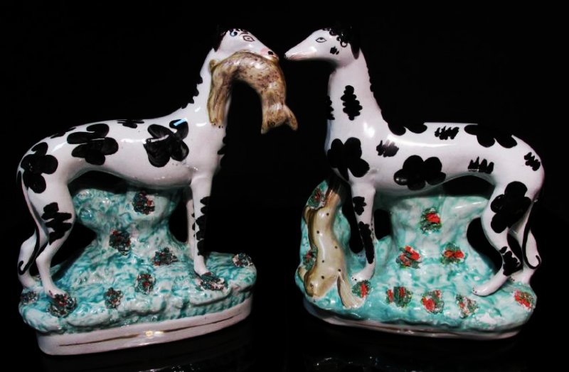 PAIR STAFFORDSHIRE DISREALI WHIPPETS W/ HARES: Pair of 19th century Staffordshire pottery disreali whippets w/ hares. Each figurine measures 10.5" tall x 9.5" long. Unmarked. Condition: professional restoration to face of one dog, professional res