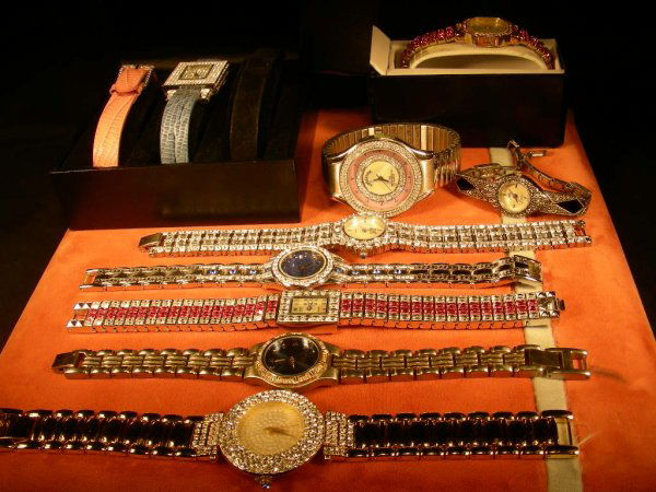 GROUP ASST COSTUME RHINESTONE WATCHES 9 PCS: Vivani quartz pink rhinestone watch in case, Real Collectibles by Adrienne watch with two additional bands in case, and 7 assorted gold tone, silver tone, rhinestone, rhinestone bevels, etc. watches.