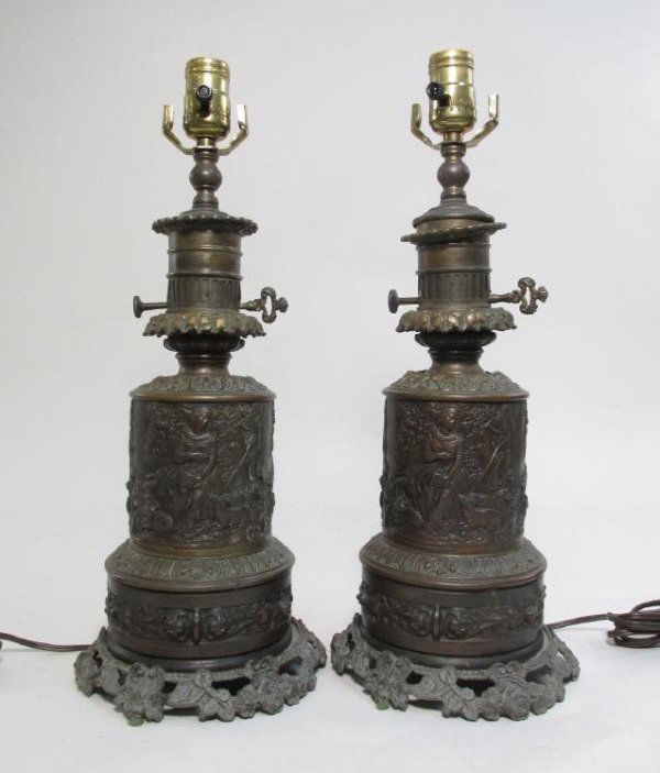 PAIR FRENCH EMBOSSED BRASS ELECTRIFIED OIL LAMPS: Pair of French embossed brass electrified oil lamps. Does not include shades or harps. Modern fixtures and wiring. Signed very small "Bourdon" twice. Condition: patina and signs of age to finish, very