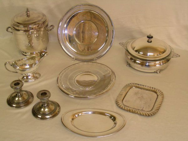 LG GRP ASSORTED SILVER PLATE HOLLOWWARE: A nice useful group of assorted silver plate serving pieces includes an Ice bucket, round covered casserole, sauce boat, hammered candlesticks, round trays and a small square tray. All generally good