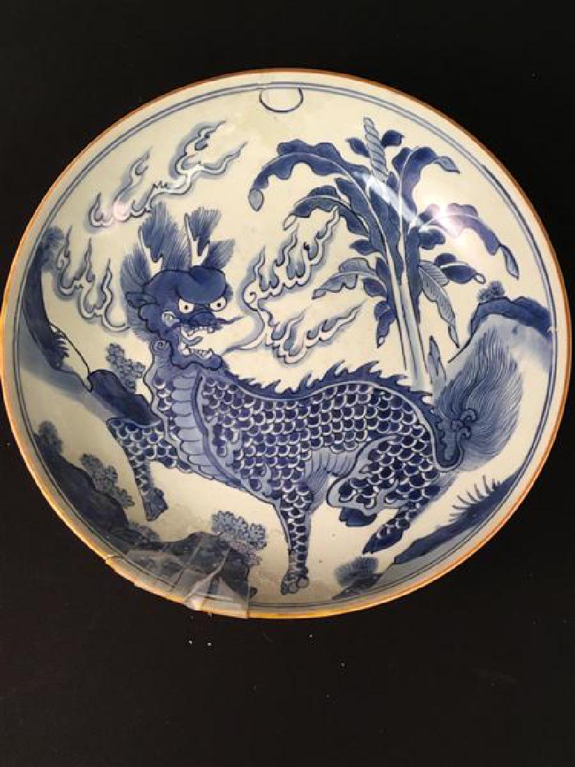 A CHINESE BLUE WHITE BOWL WITH FOO DOG: A CHINESE BLUE WHITE PORCELAIN BOWL WITH FOO DOG DECORATION: Measures 13.5" x 3.25" tall. Condition: break to rim (pieces taped to bowl), old poor repairs, hairline to rim approx 2.5" long. See images