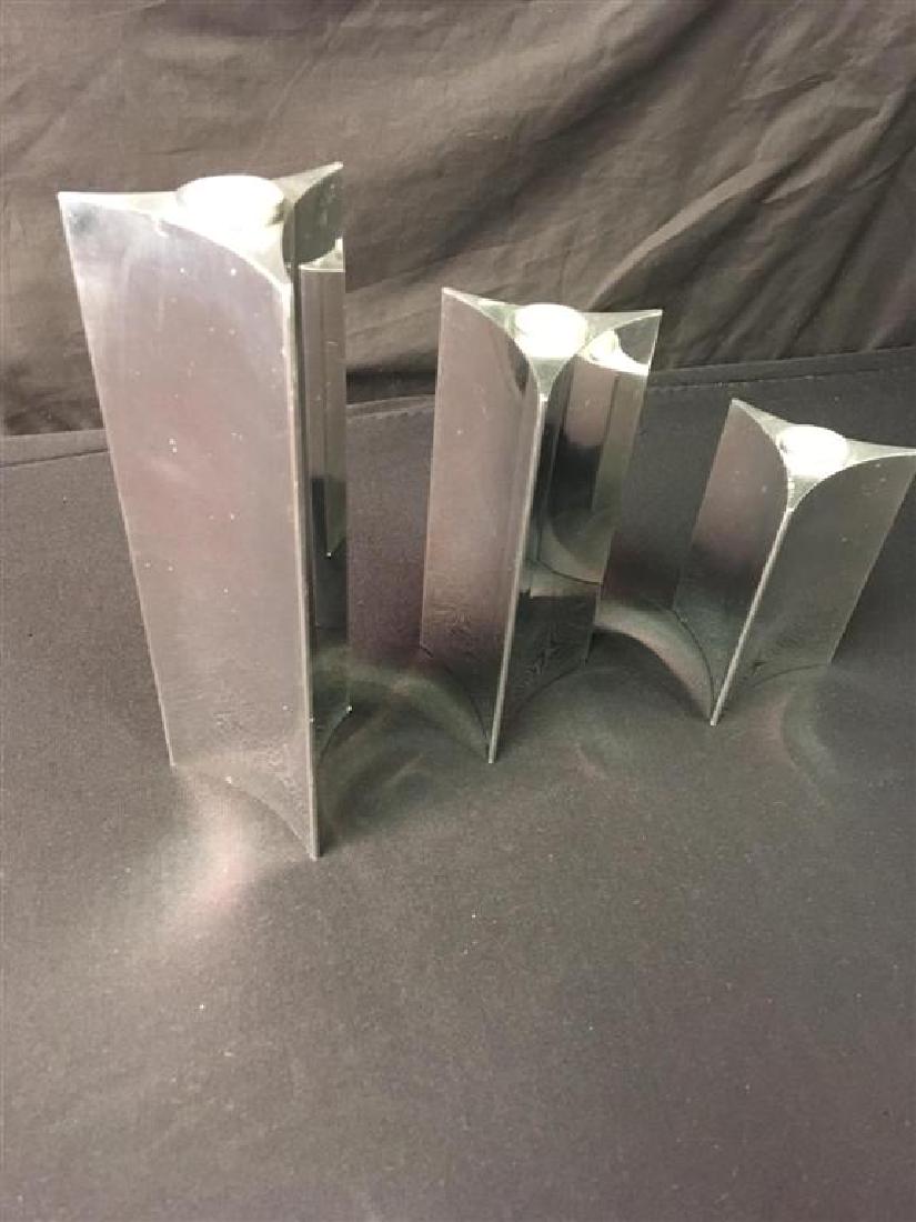 VERNER PANTON FOR GEORG JENSEN: 3 CANDLESTICKS: Verner Panton (Denmark 1926-1998) - Candlestick Starlight. Production year 1991. Starlight Candlestick with a triangular base in three sizes. 9.25", 7", 4,75", Material: polished aluminum Manufacturer