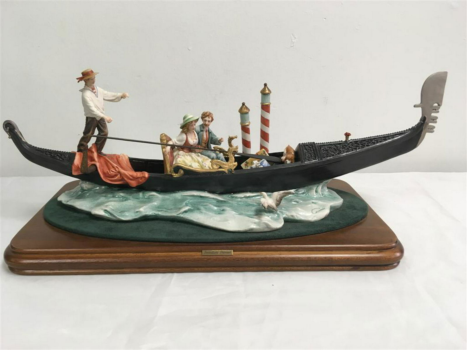 CAPODIMONTE PORCELAIN: LA GONDOLA: CAPODIMONTE PORCELAIN: LA GONDOLA - ltd edition 383/100 large porcelain figure set on a felt oval and then wood base. Measures: 20" x 8". Condition: repair to front tip of Gondola.