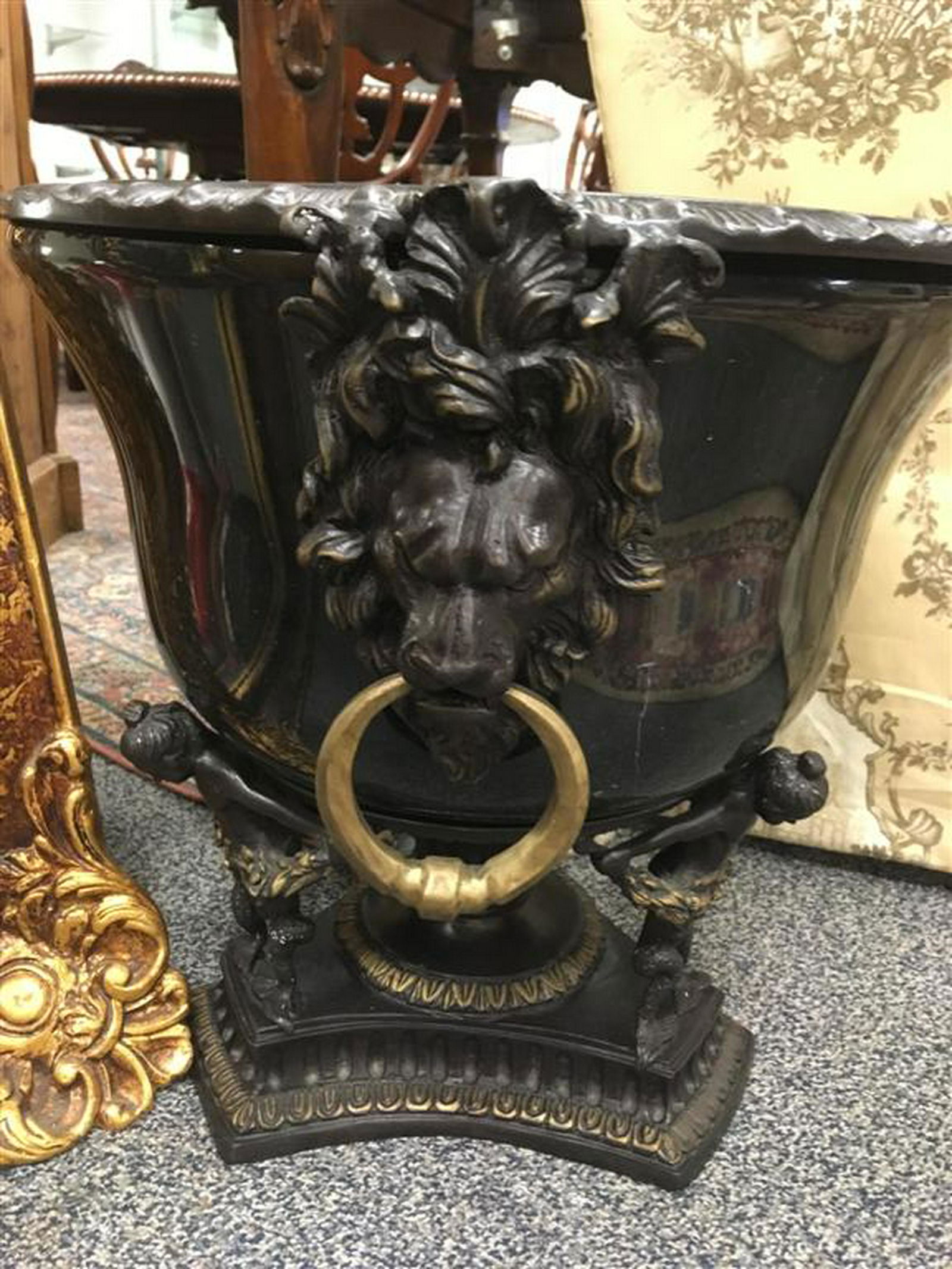 MAITLAND SMITH BRONZE AND BLACK MARBLE CACHE POT: Maitland-Smith black and white variegated marble cache pot with bronze mounted rim with lion's heads. Pot sits on a bronze base with cherubs. 19 1/2" W x 17" H with 9" deep pot.
