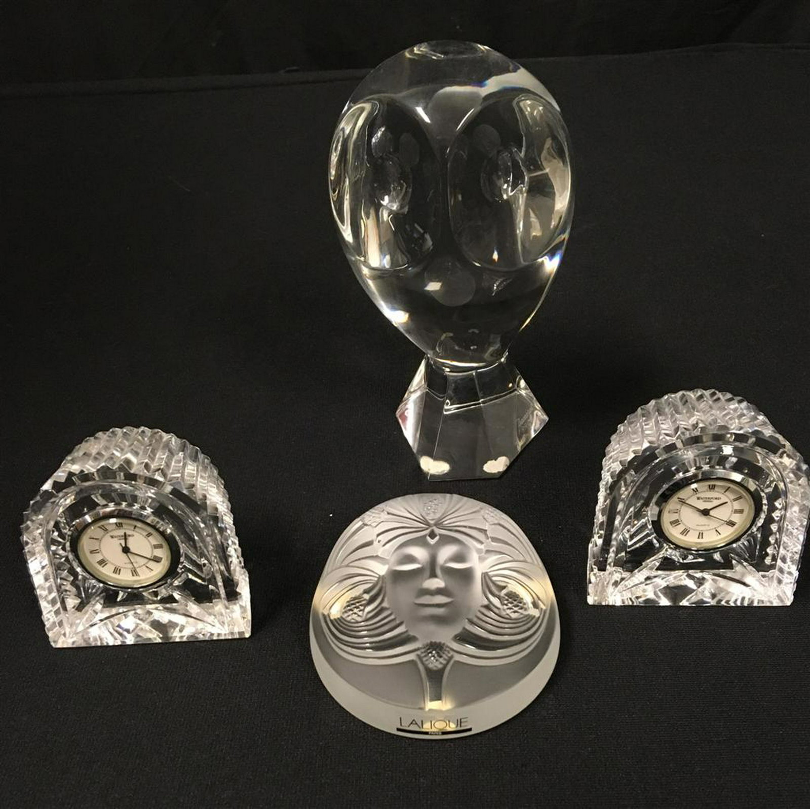 LALIQUE BACCARAT WATERFORD CRYSTAL LOT, RIGOT 4PCS: Crystal lot comprised of a Baccarat owl by R. Rigot, a Lalique "Psyche" paperweight, and two Waterford desk clocks. Owl measures 6.65" tall, and Lalique paperweight measures 3.5" diameter. All signed.