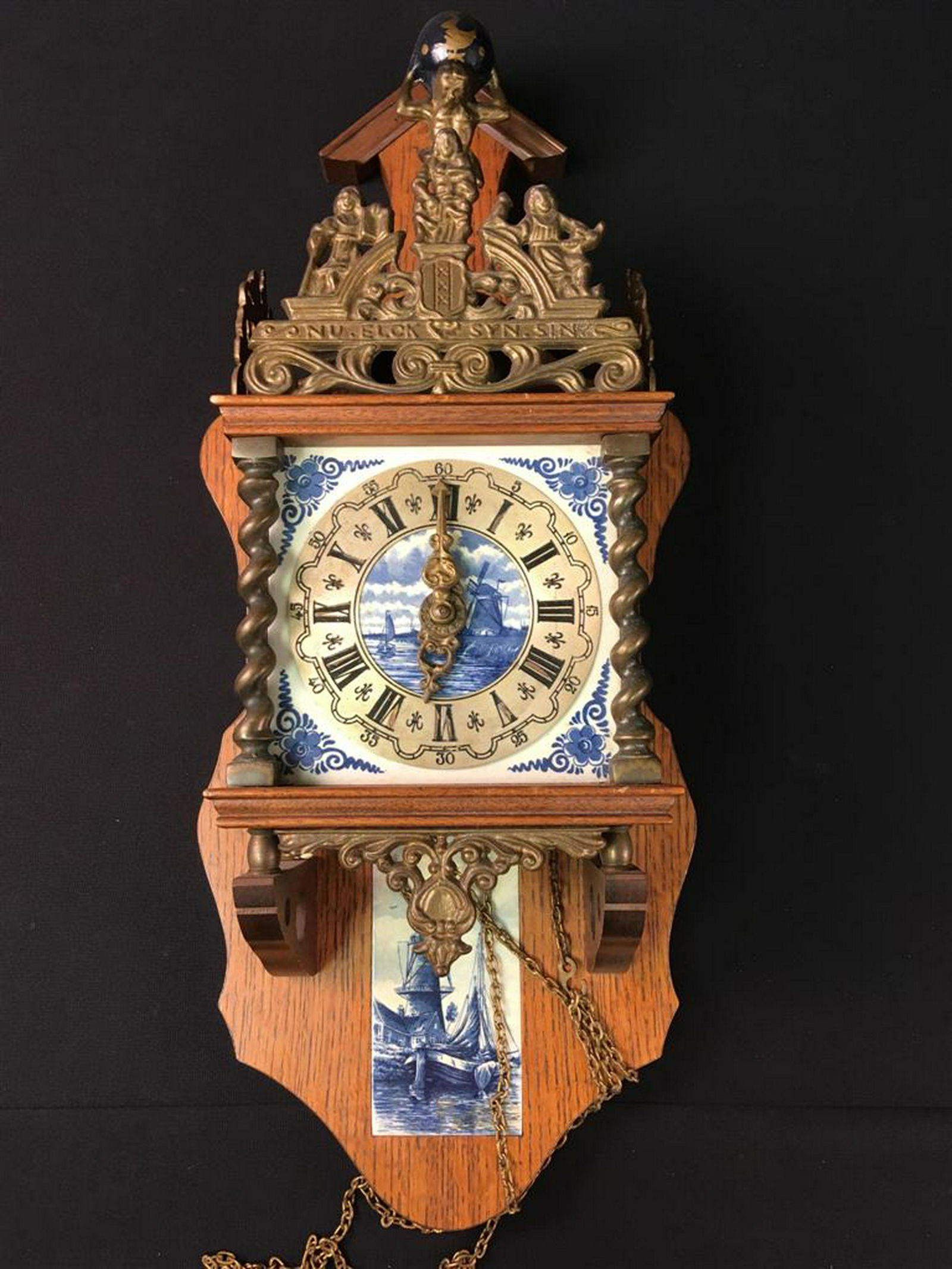 DUTCH DELFT BLUE WEIGHT DRIVEN WALL CLOCK: Dutch Delft Blue Dutch Weight Driven Wall Clock - oak case, German brass movement, brass embellishments, atlas figure, and Delft blue porcelain inserts. (No weights, no key). Measures: 24" x 9" x 6" d