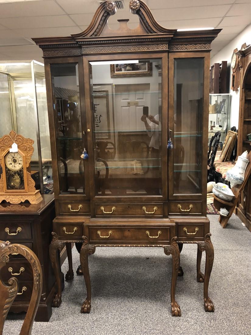 BAKER FURNITURE CHIPPENDALE STYLE WALNUT BREAKFRON: Baker Furniture Chippendale style walnut breakfront. Claw foot, broken pediment at top, stepped back sides. Middle cabinet has three large glass shelves, side cabinets each have three small shelves. T