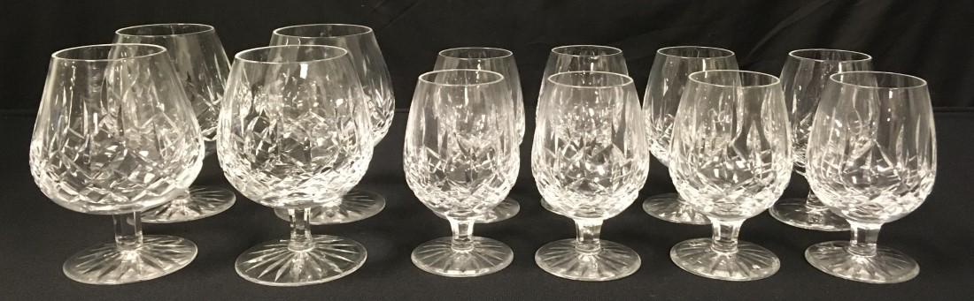 TWELVE WATERFORD "LISMORE" CRYSTAL BRANDY GLASSES: Lot of twelve Waterford "Lismore" pattern crystal brandy glasses in two sizes. Includes (4) full size snifters 5.25" tall, and (8) smaller 4.5" tall glasses. Each piece acid etched with makers mark on