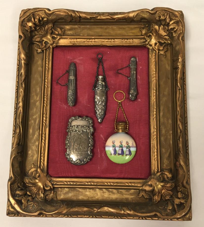 STERLING PERFUME BOTTLE CHATELAINE ASSEMBLAGE: Sterling chatelaine perfume bottle framed assemblage. Includes three chatelaine perfume bottles believed to be sterling (untested, mark is not visible as mounted), and a sterling match box (untested, 
