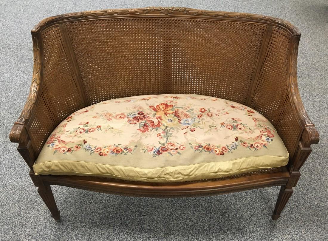 FRENCH LOUIS XVI STYLE DOUBLE CANED SETTEE: Late 19th - Early 20th C French Louis XVI style double caned settee with carved frame and petite point and silk covered, down-filled seat cushion. Condition: very good with no breaks to caning, origin