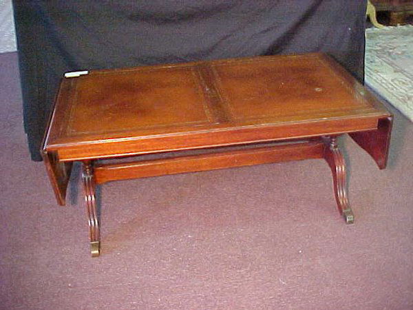 DUNCAN PHYFE STYLE DROP COFFEE TABLE: DUNCAN PHYFE STYLE DROP COFFEE TABLE Vintage leather top Duncan Phyfe drop end table. Wear to finish. Measures 44" long by 23" wide and 18" tall. When drop sides lifted, 59" long.