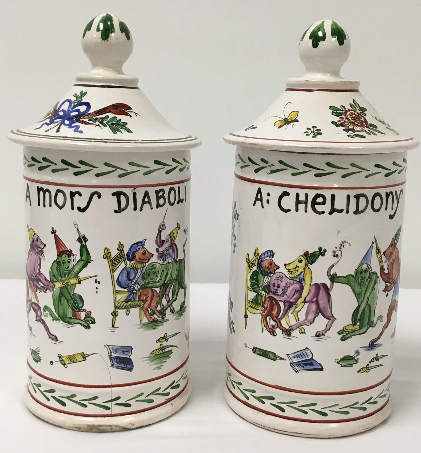PAIR ANTIQUE FRENCH FAIENCE LIDDED CANISTERS: Pair of antique French faience lidded pottery canisters. Both painted with medical themed scenes: one canister reading "A: Chelidony", and the other "A Mors Diaboli". Both signed "HC" on base. Conditi