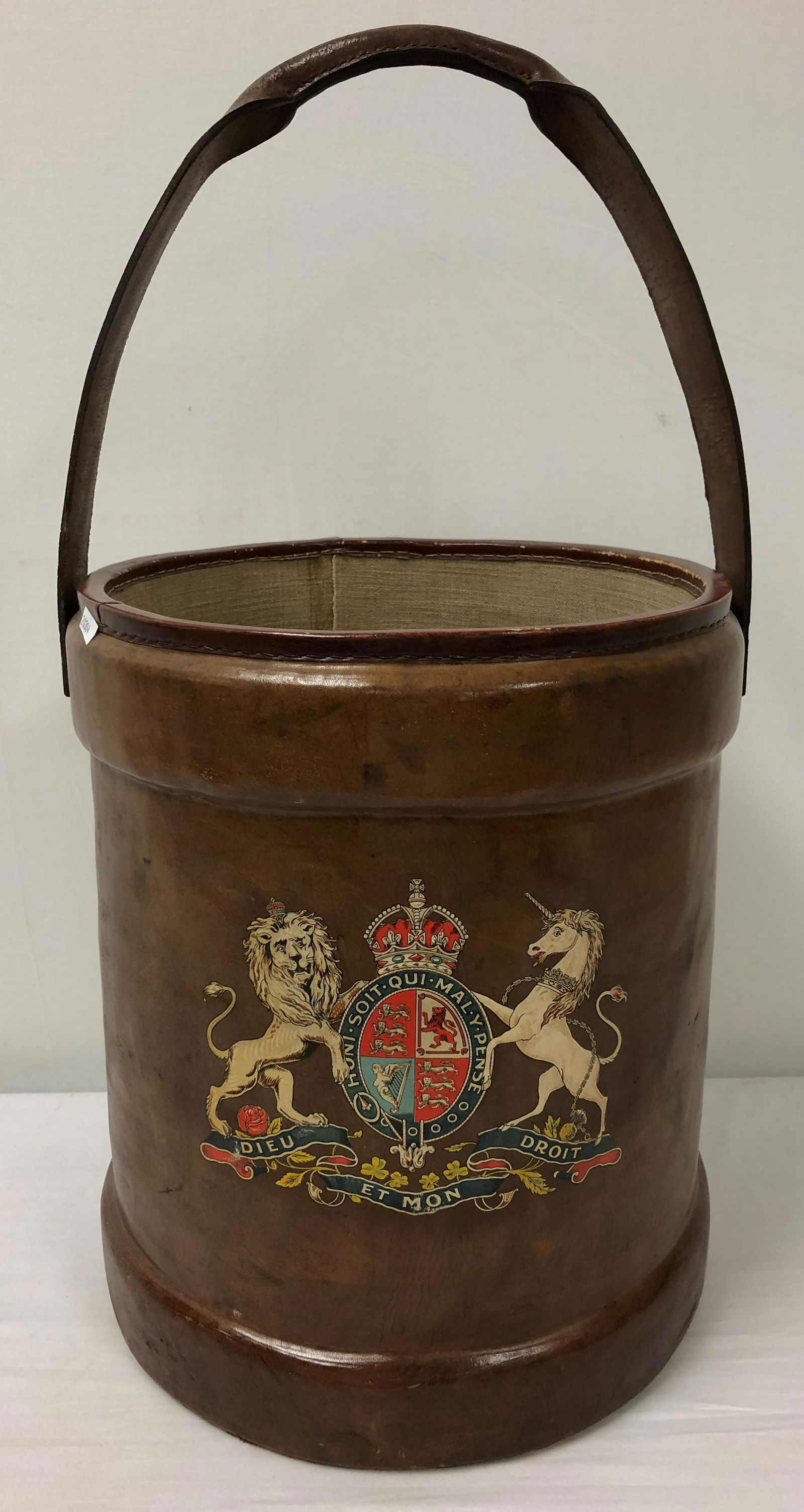 ANTIQUE ENGLISH LEATHER ARMORIAL FIRE BUCKET: English 19th century leather fire bucket decorated with an armorial crest. Re-lined interior. Condition: minor signs of normal age and use, see images. Measures 16.5" tall x 14" wide. Weight: 6.8 lbs.