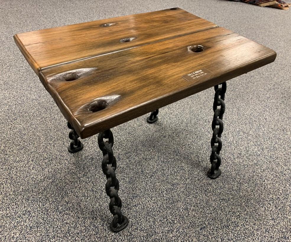 ANTIQUE SHIPWRECK PLANK TABLE: F.W. WHEELER: Antique shipwreck planks converted into a side table. Planks from the F.W. Wheeler, lost Dec, 3 1893 in Michigan City, Indiana. Name plate with info attached. Solid chain style legs. Condition: minor 
