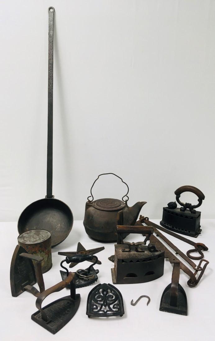 ANTIQUE PRIMITIVE CAST IRON TOOLS, IRONS, ETC.: Lot of antique primitive cast iron tools, irons, hooks, etc. Includes a cast iron kettle, an iron star, iron spike, fireplace hanger or fire jack, a lithograph tin, and various irons. Condition: signs
