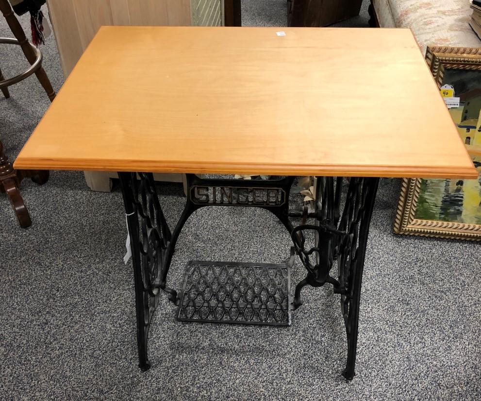 SINGER SEWING MACHINE BASE W/ NEWER WOOD TOP: Table made out of a Singer sewing machine base, fitted with a newer wood top. Measures 30.5" long x 23.25" wide and 29" tall. Condition: good, see images. Weight: approx. 45 lbs.