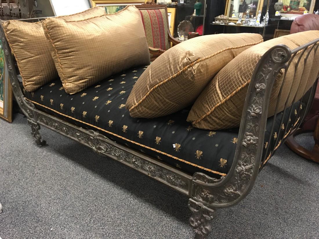 CONTINENTAL CAST IRON CAMPAIGN DAYBED: Continental cast iron campaign daybed on castors. Measures a total of 76" long x 38" wide and 38.5" tall. Art Nouveau style floral design on the ends. Sold with wooded baseboard for under cushion. Bla