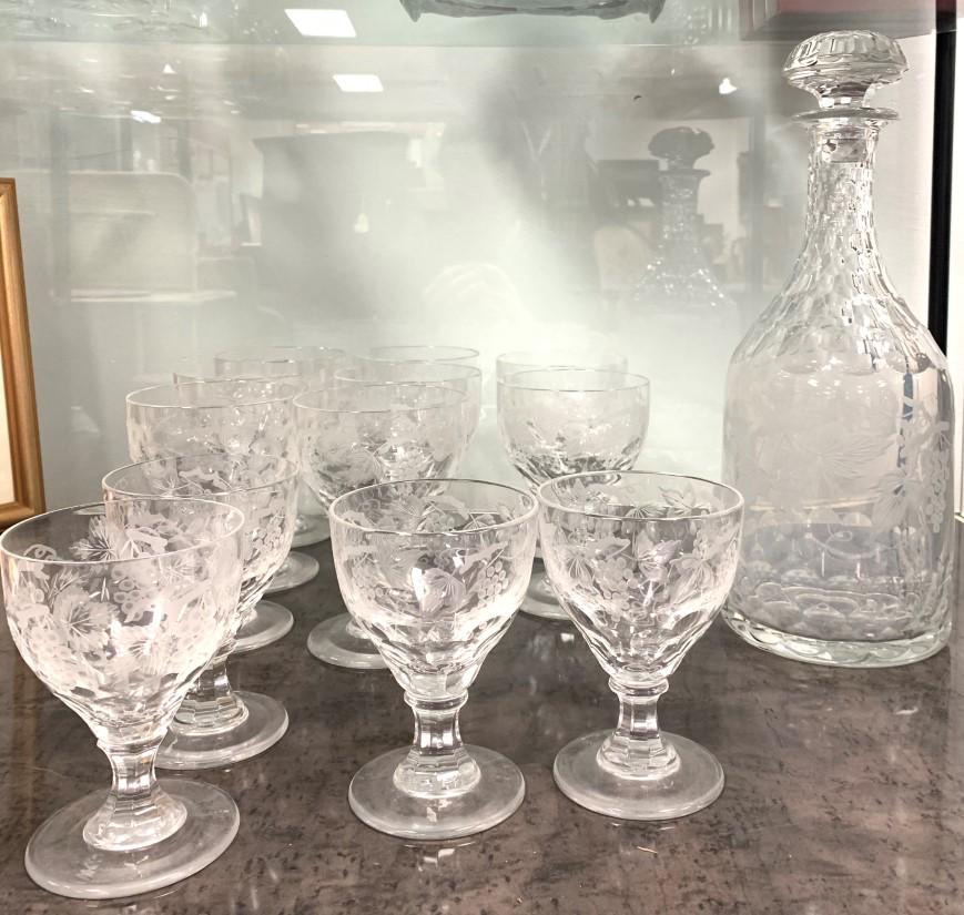 WILLIAM YEOWARD CUT & ENGRAVED CRYSTAL DECANTER SE: William Yeoward cut and engraved crystal decanter set. Each piece cut and engraved with a grapevine pattern. Includes a 14.5" decanter, (4) 5" stems, and (8) 6" tall stems. Signed on base with William