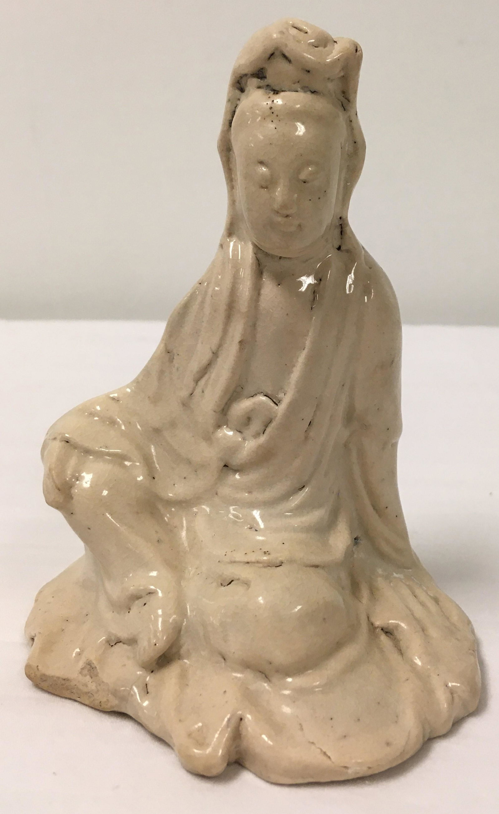 CHINESE MING DYNASTY QUAN YIN BLANC DE CHINE FIGUR: Small Chinese Ming Dynasty blanc de chine glazed pottery figure depicting a seated Quan Yin. Measures 5.5" tall x 4.25" wide and 3.5" deep. Condition: good, signs of age and wear as expected, see imag