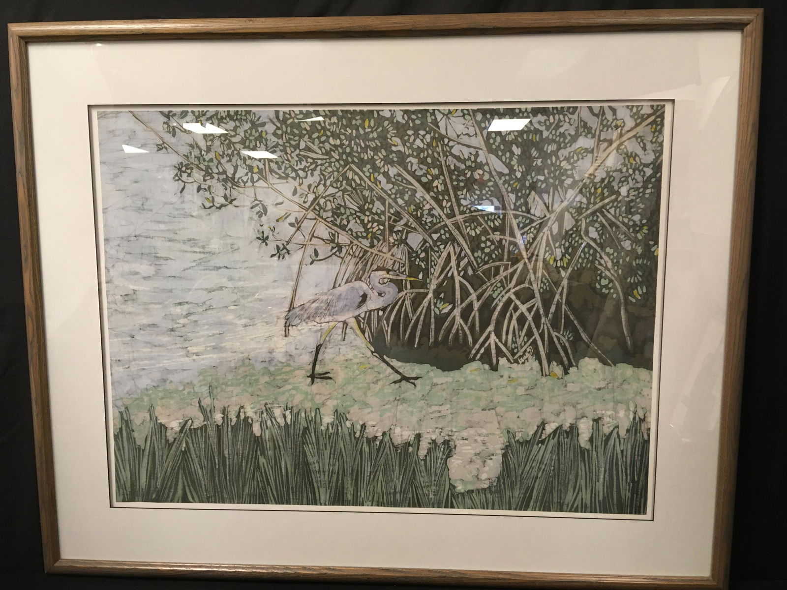 FRAMED NATALIE GUESS BATIK: HERON & MANGROVES: Framed batik by Naples, Fl artist Natalie Guess. Depicting a heron among mangroves. Frame measures a total of 33.5" tall x 42" wide. Weight: 16.5 lbs.