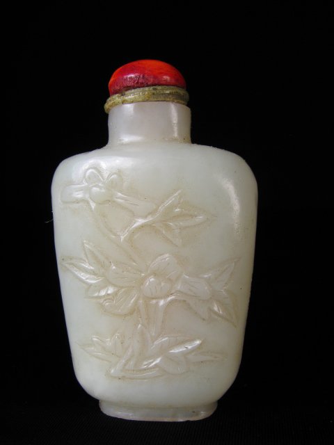 19TH C CARVED CHINESE MUTTON FAT JADE SNUFF BOTTLE: Late 19th/ early 20th century carved floral Chinese mutton fat jade snuff bottle with coral cabochon stopper. China is incised on the base. Measures 2 1/4" tall by 1 1/4" wide. Condition is good, see