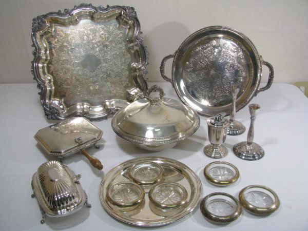 SILVER PLATE ASSORTED TRAYS FOOTED BUTTER DISH ET: Assorted silver plate includes round tray with handles, covered bowl with glass liner, silent butler, small round tray with engraved names, cigarette lighter, pair of candle sticks, six coasters, and