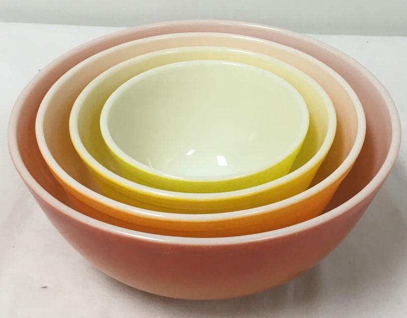 VINTAGE PYREX ORANGE YELLOW COLORED MIXING BOWLS: Lot of four vintage Pyrex orange - yellow colored mixing bowls, largest is 10.25" diameter, and smallest 5.75". Each one marked on base. Condition: very light signs of use to colored finish, see image