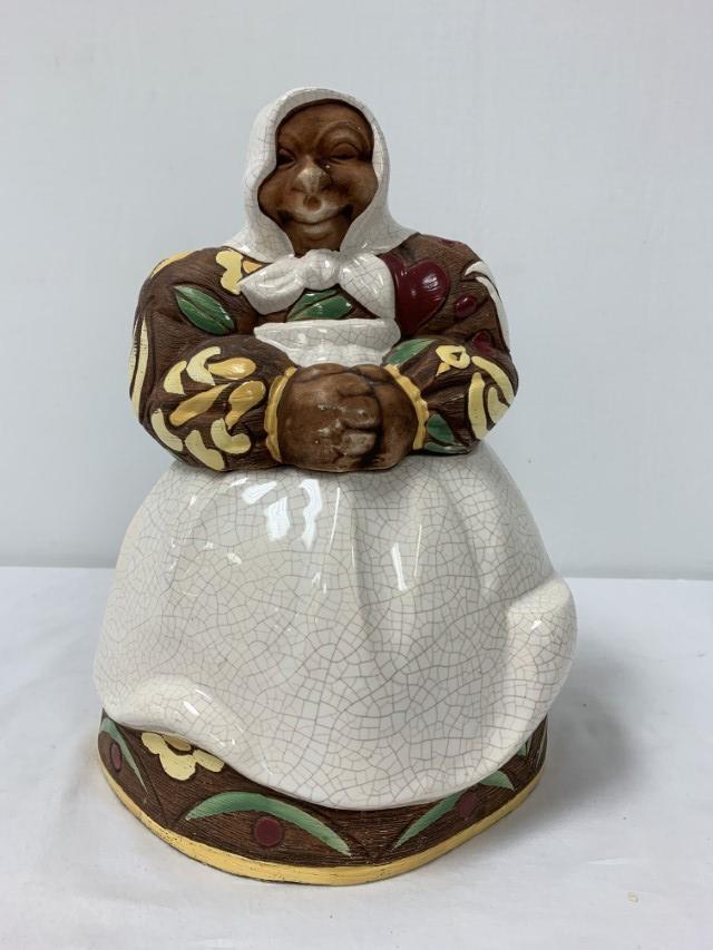 BRAYTON CALIFORNIA POTTERY "MAMMY" COOKIE JAR: Brayton California Pottery "Mammy" cookie jar measuring 12.75" tall x 9" wide. Signed on base. Condition: minor wear to paint on hands, a few small flakes to base rim, chip to backside of lid, see ima